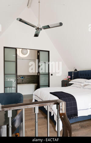 Silber Deckenventilator in weiß Schlafzimmer mit Ensuite-Bad Stockfoto