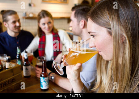 Junge Frau Verkostung Bier im Pub, Dorset, Bournemouth, England Stockfoto