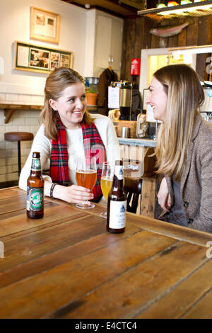 Junge Frauen, die trinken Bier im Pub, Dorset, Bournemouth, England Stockfoto