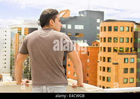 junger Mann, Blick auf Quito Stadtblick vom Balkon Stockfoto