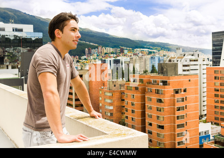 junger Mann, Blick auf Quito Stadtblick vom Balkon Stockfoto