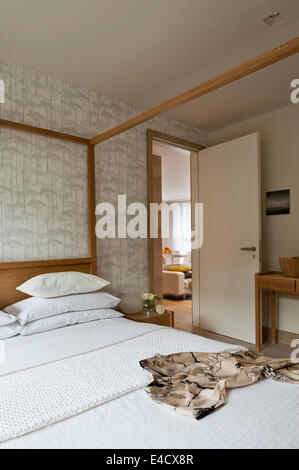 Verspiegelte Schrankwand im Schlafzimmer mit Hana Eiche Himmelbett von Lebensraum und Putkinotko Wallpaper von Marimekko Stockfoto
