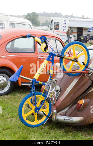 Ratte-VW-Käfer auf einem Campingplatz mit einem Raleigh Fahrrad angebracht zu den Booten Stockfoto