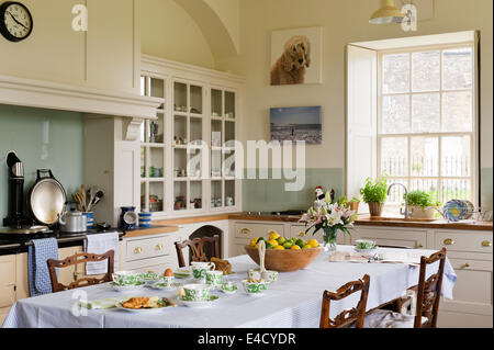 Mouseman Stühle von Thompson von Kilburn und rund um einen Esstisch in einer Landhausküche. Stockfoto