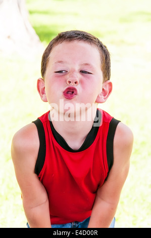 Niedliche kleine Junge wird spielerisch und machen lustige Gesichter Stockfoto