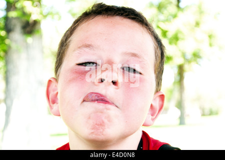 Niedliche kleine Junge wird spielerisch und machen lustige Gesichter Stockfoto