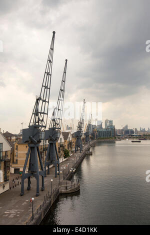 Alten Kränen auf das Dockside Royal Victoria Dock in London, mit Blick auf Canary Wharf. Stockfoto