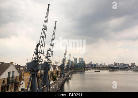 Alten Kränen auf das Dockside Royal Victoria Dock in London, mit Blick auf Canary Wharf. Stockfoto