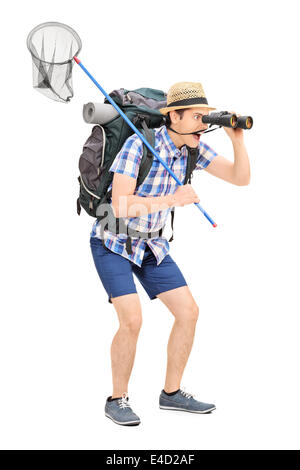 In voller Länge Portrait von einem Kerl mit dem Schmetterling net schauen durch ein Fernglas Stockfoto