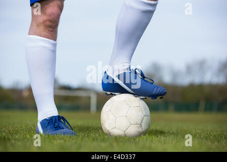 Football-Spieler mit dem Ball stehend Stockfoto