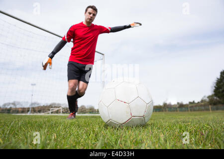 Torhüter in rot treten Ball vom Ziel Stockfoto