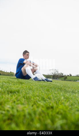 Football-Spieler in blau eine Pause auf dem Spielfeld Stockfoto