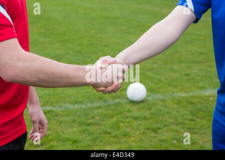 Fußball-Spieler in blau und rot, die Hände schütteln Stockfoto