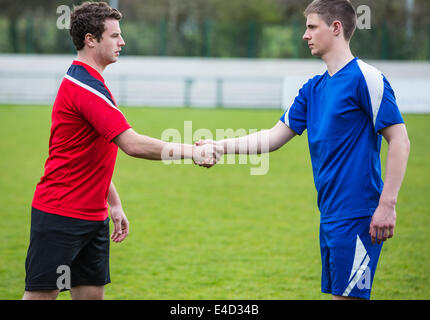 Fußball-Spieler in blau und rot, die Hände schütteln Stockfoto