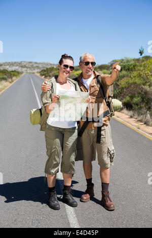 Wandern paar Blick auf Karte auf der Straße und zeigt voraus Stockfoto