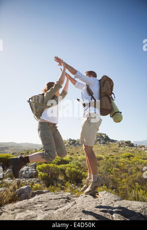 Wandern paar springen und jubeln über felsiges Gelände Stockfoto