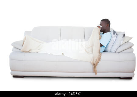 Kranker Mann auf seiner Nase weht Couch liegen Stockfoto