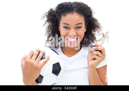 Hübsche Fußballspieler in weiß halten Gewinner Figur und ball Stockfoto