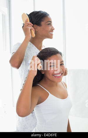 Mutter und Tochter gemeinsam ihre Haare Bürsten Stockfoto