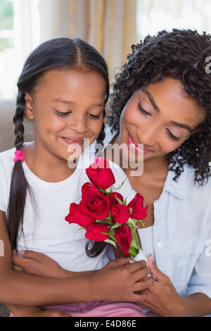 Ziemlich Mutter mit ihrer Tochter halten Rosen auf der Couch sitzen Stockfoto