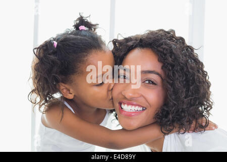 Hübsche Mutter mit ihrer Tochter ihre Wange küssen Stockfoto