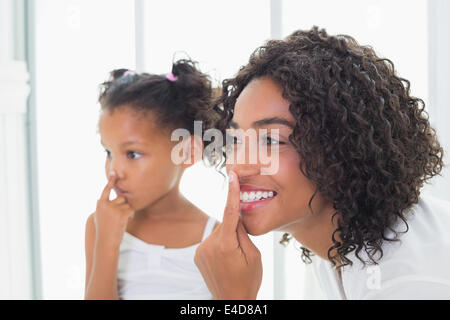 Mutter ziemlich putting Gesichtscreme auf mit ihrer Tochter Stockfoto