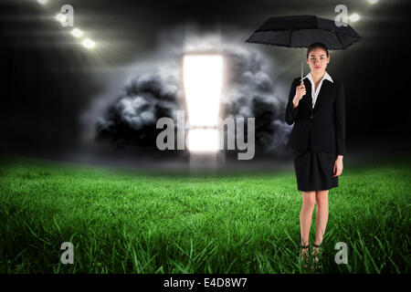 Zusammengesetztes Bild junge Geschäftsfrau hält Regenschirm Stockfoto