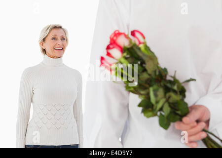 Mann versteckt Strauß Rosen aus älteren Frau Stockfoto