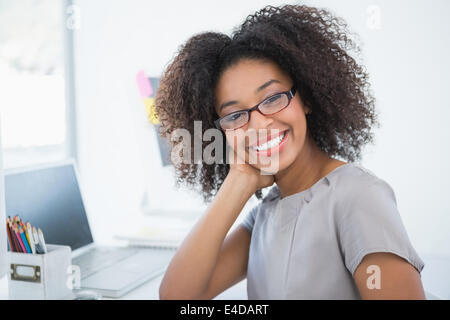 Junge hübsche Designer lächelnd in die Kamera an ihrem Schreibtisch Stockfoto
