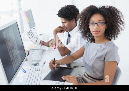 Junge hübsche Designer Blick in die Kamera an ihrem Schreibtisch Stockfoto