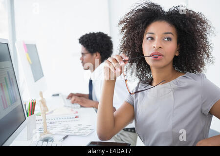 Junge Editor denken an ihrem Schreibtisch Stockfoto