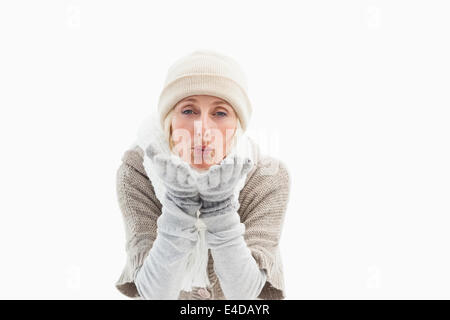 Reife Frau in Winterkleidung weht Kuss Stockfoto