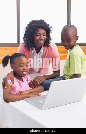 Niedlichen Geschwister mit Laptop zusammen mit Mutter Stockfoto