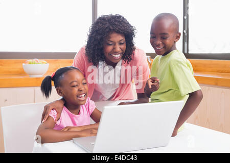 Niedlichen Geschwister mit Laptop zusammen mit Mutter Stockfoto