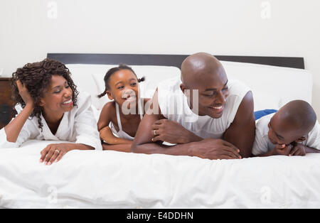 Glückliche Familie lachen zusammen im Bett Stockfoto