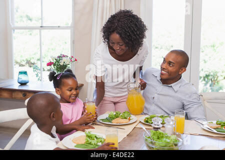 Mutter mit Saft zu ihrer Familie zu Mittag Stockfoto