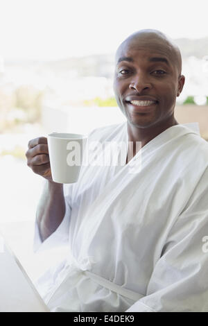 Gut aussehender Mann im Bademantel Kaffeetrinken außerhalb Stockfoto