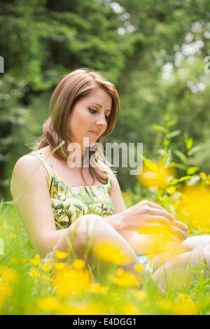 Nachdenkliche Frau entspannend im Feld Stockfoto