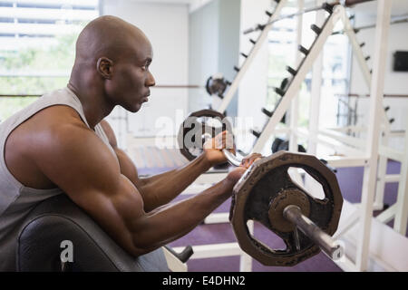 Muskulöser Mann heben Langhantel im Fitness-Studio Stockfoto