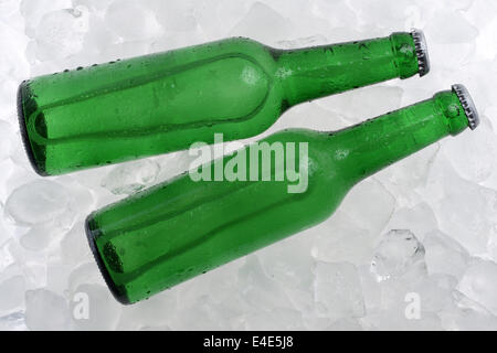 Kaltes Bier in Flaschen auf Eiswürfel Stockfoto