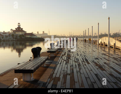 Drei Menschen, die am frühen Morgen Fuß entlang der Promenade in Long Beach Marina in Los Angeles Stockfoto