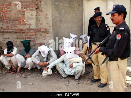 CIA Polizeibeamte sind beraubt Währung auszusetzen, Waffen und Verfügbarmachen Verbrecher inhaftiert im Intelligenz basierte Raid, während einer Pressekonferenz am CIA Gangesebene Singh Polizeistation in Lahore am Mittwoch, 9. Juli 2014 statt. Stockfoto