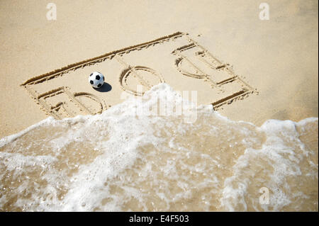 Einfache Strichzeichnung Fußball Spielfeld Taktik Board mit Fußball im Sand am brasilianischen Strand mit ankommenden Welle Stockfoto