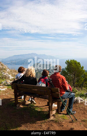 Gruppe von Menschen sitzen auf einer Sitzbank mit Blick auf Capri Landschaft, Capri, Kampanien, Italien, Europa Stockfoto