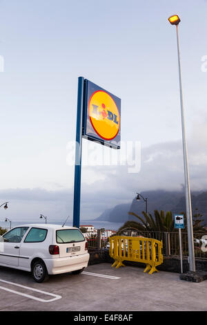 Parkhaus und Lidl-Supermarkt unterzeichnen in Puerto Santiago mit Blick auf die Klippen von Los Gigantes, Teneriffa, Kanarische Inseln, Spanien. Stockfoto