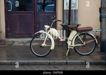 Ein altes Moped, angekettet an einen Pfosten auf einer Straße in Krakau. Stockfoto