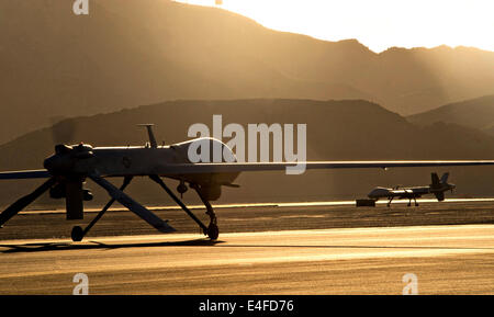 Ein MQ-1 Predator und MQ-9 Reaper unbemannten taxi zur Startbahn in Vorbereitung für den Start bei Sonnenuntergang 13. Juni 2014 Stockfoto