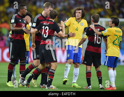 Deutschland? s Thomas Mueller (13) argumentiert mit Brasiliens David Luiz (3R) während der FIFA WM 2014 Halbfinalspiel zwischen Brasilien und Deutschland im Estadio Mineirão in Belo Horizonte, Brasilien, 8. Juni 2014. Foto: Marcus Brandt/Dpa (es gelten Einschränkungen: redaktionelle Nutzung, nicht ausschließlich in Verbindung mit einem kommerziellen Unternehmen - Bilder dürfen nicht verwendet werden, in irgendeiner Form von alert-Dienst oder Push-Dienst von jeder Art einschließlich per Benachrichtigung Mobildienste Downloads auf mobilen Geräten oder MMS-messaging - Bilder müssen als Standbilder erscheinen und müssen nicht emulieren Spiel Action video-Footage - keine Änderung erfolgt Stockfoto