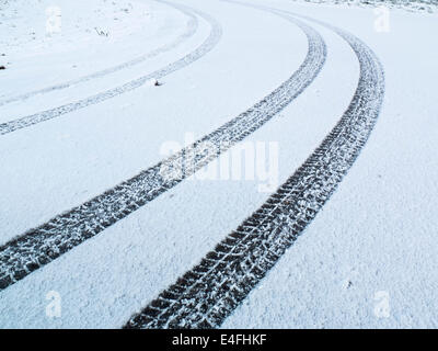 Auto-Reifen-Spuren im Schnee Stockfoto