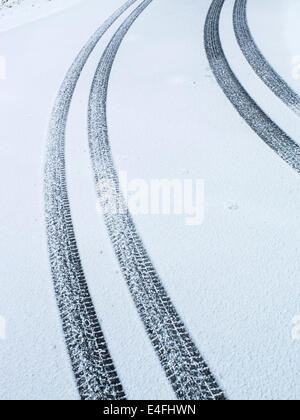 Auto-Reifen-Spuren im Schnee Stockfoto